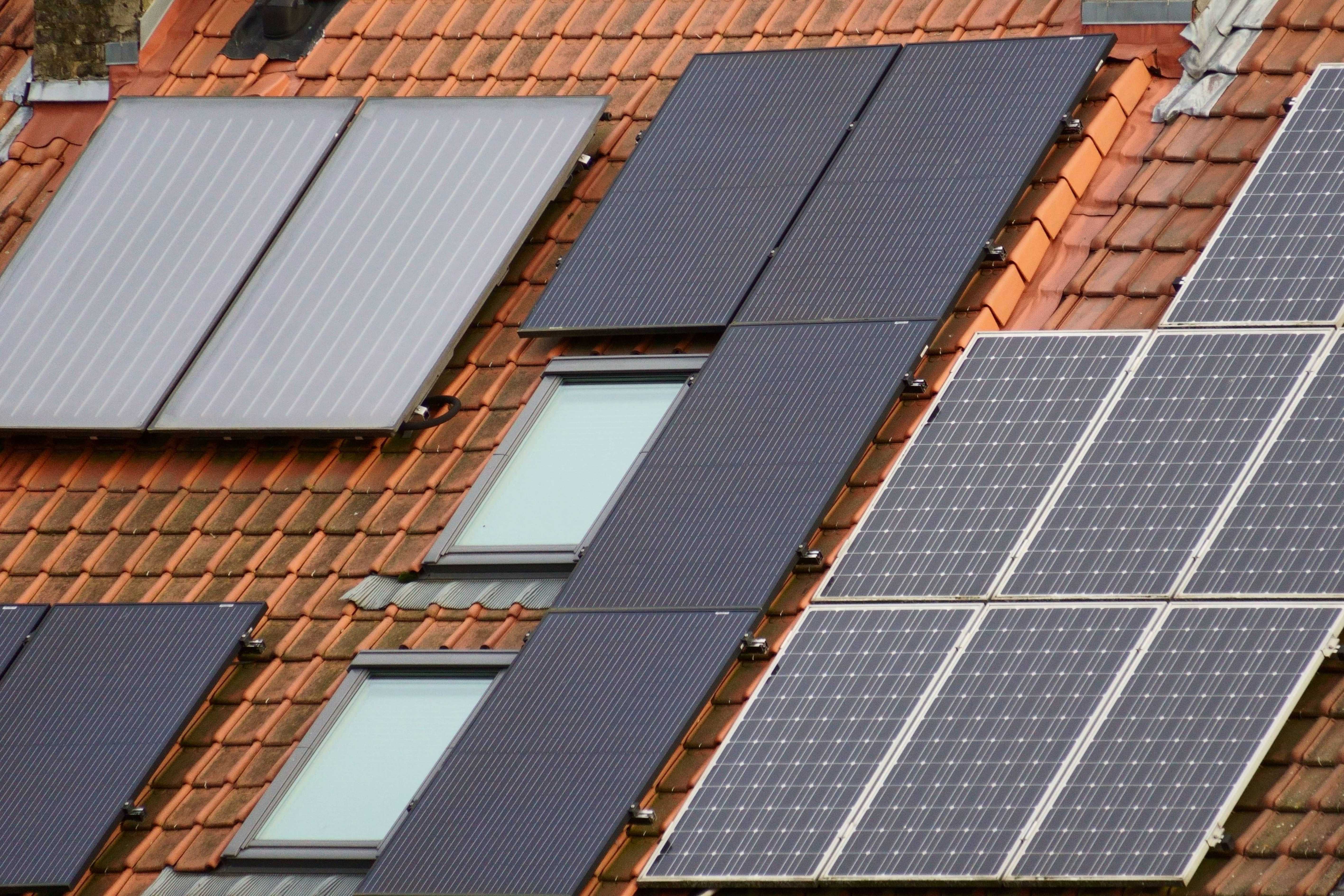 Rooftop solar panels and skylights on a terracotta tile roof, illustrating how to get Long Island solar with no monthly payment through the Participate Energy Program.