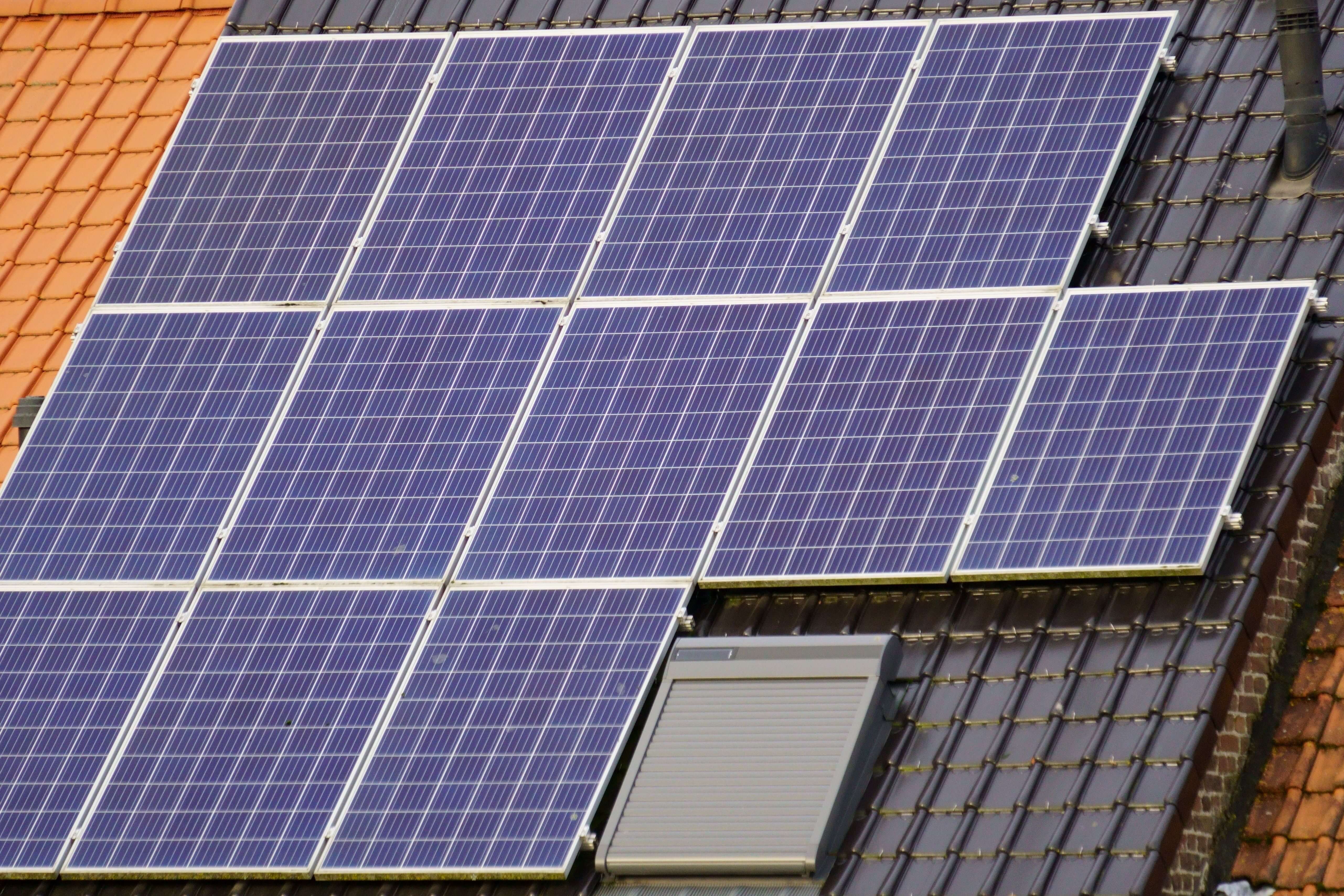 Blue rooftop solar panels installed on a dark tile roof, showing how solar panels can really lower your PSEG Long Island electric bill.