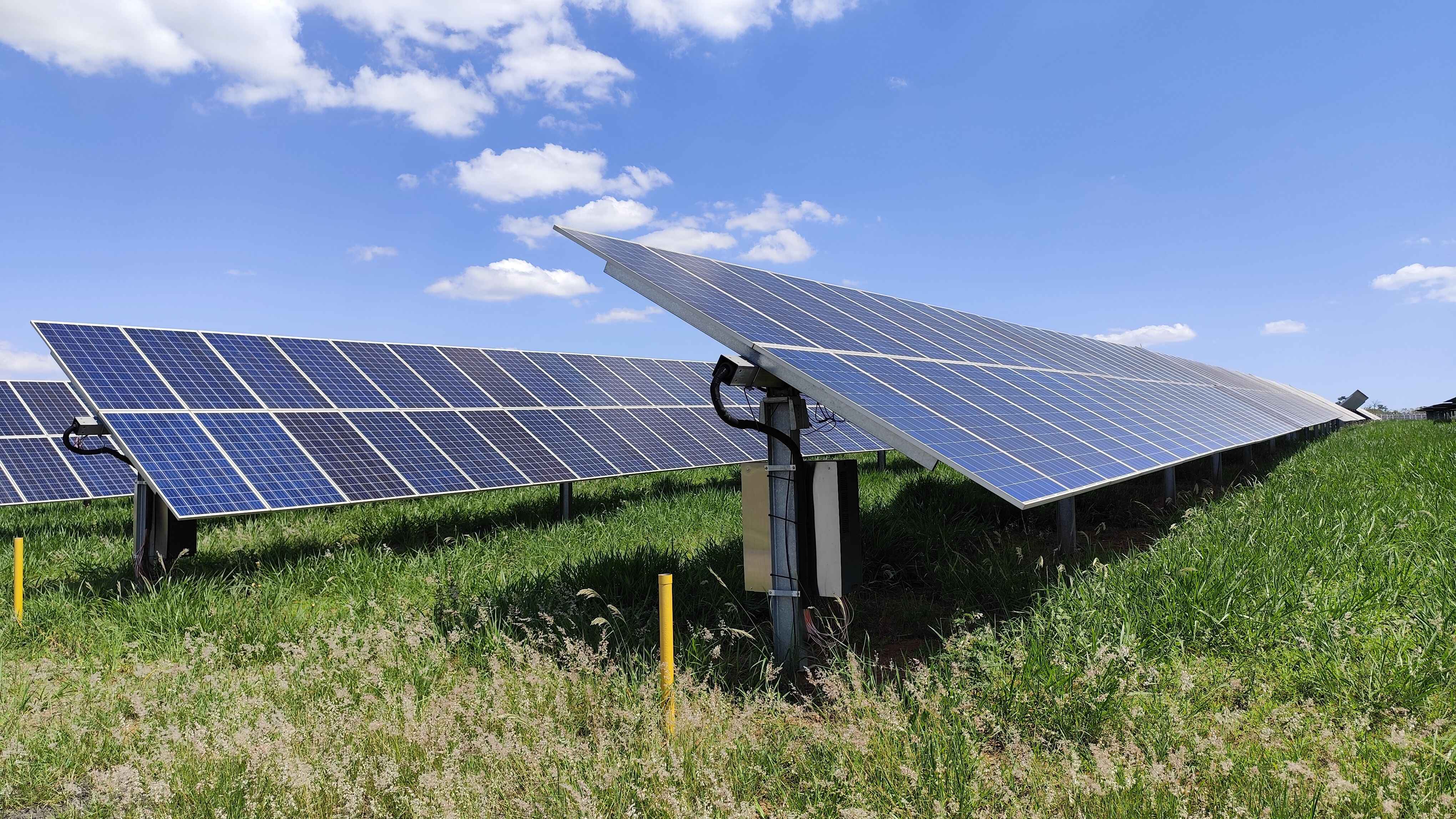 Ground-mounted solar panels under a blue sky, illustrating whether Long Island solar panels work in winter and what to know before the cold weather arrives.