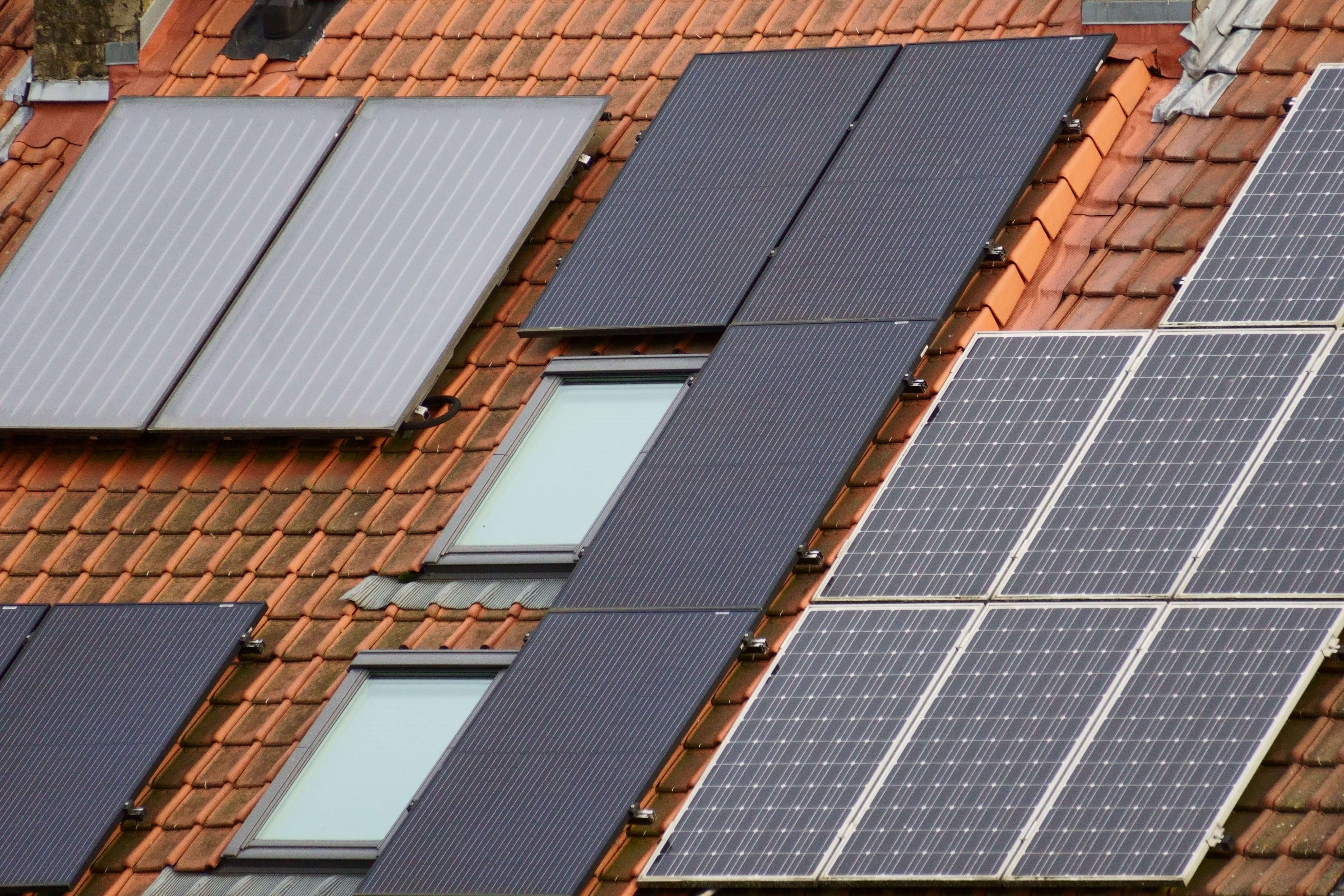 Rooftop solar panels installed on red tile roofs, a solution for homeowners asking why PSEG Long Island electric bills are so high in 2026.